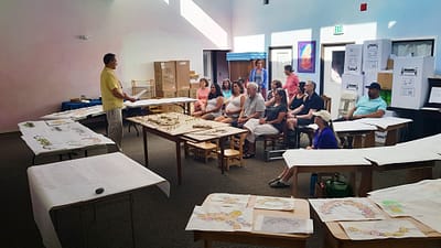 Závěrečná presentace Oldřicha Hozmana ve škole v Reno. Na stolech jsou vystaveny modely a architektonická studie areálu školy.